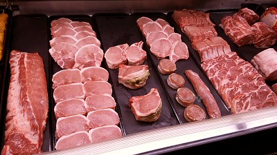 A variety of fresh pork products in a showcase